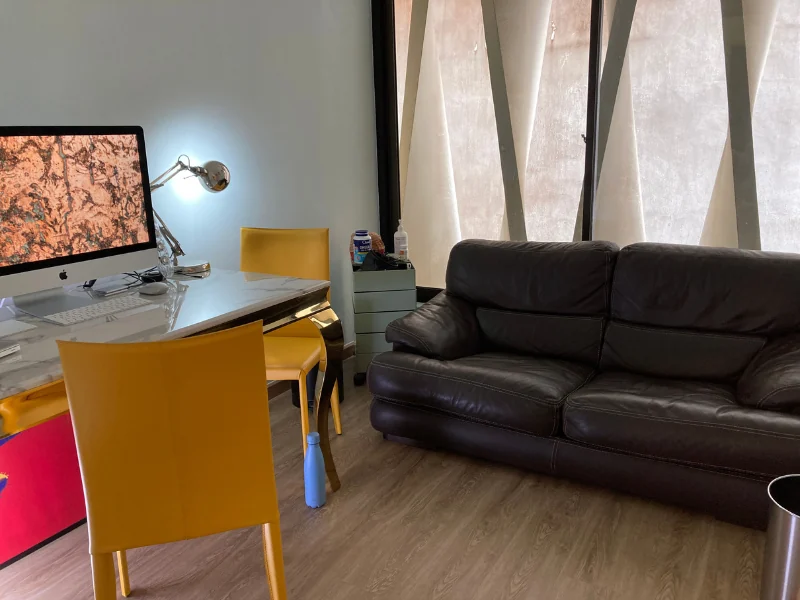 Consultation room at 150 Cecil Street with a desk and sofa.